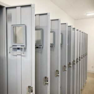 スポーツ施設の更衣室とロッカーを点検するスタッフ