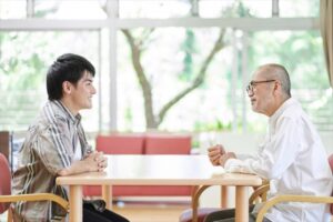 衛生対策に配慮して家族と面会する高齢者施設の利用者