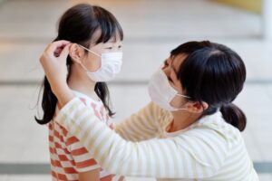家族が集まる室内で咳エチケットを行う人