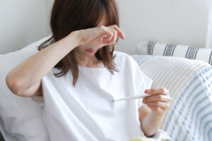残暑の体調不良で体温を確認する人